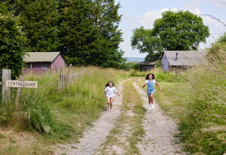 Zwei Kinder rennen einen Feldweg entlang bei BoerenBed Manor Farm, einem Ferienpark in Südostengland.