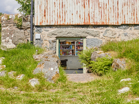 Ein kleiner Laden in einer Steinmauer bei BoerenBed Pant y March Farm, einem Ferienpark in Wales, Großbritannien.