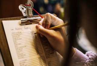 En person udfylder en bestillingsliste på et clipboard på BoerenBed Lunsford Farm feriepark i England.