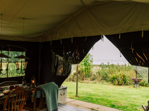 View from a tent with dining table at BoerenBed Lunsford Farm holiday park in South East England, United Kingdom.