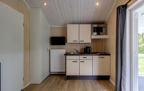 Angolo cottura compatto al Tiny House Deluxe dell’Holiday park Latour, Paesi Bassi, con microonde.