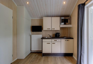 Pequeña cocina en Tiny House Deluxe del Holiday park Latour, Países Bajos, con microondas y hervidor.