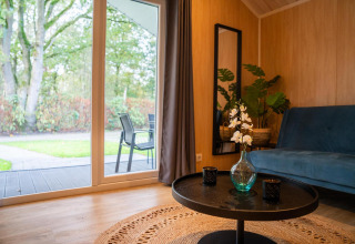 Acogedora sala de Tiny House Deluxe con vista al jardín en Holiday park Latour, Países Bajos.