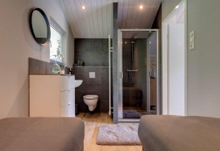 Modern bathroom in Tiny House Deluxe at Holiday park Latour in the Netherlands with toilet and shower.