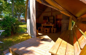 Safari teltet Tent Lodge Liberta ved Camping Merendella, med terrasse, træbænk og udendørs spiseområde.