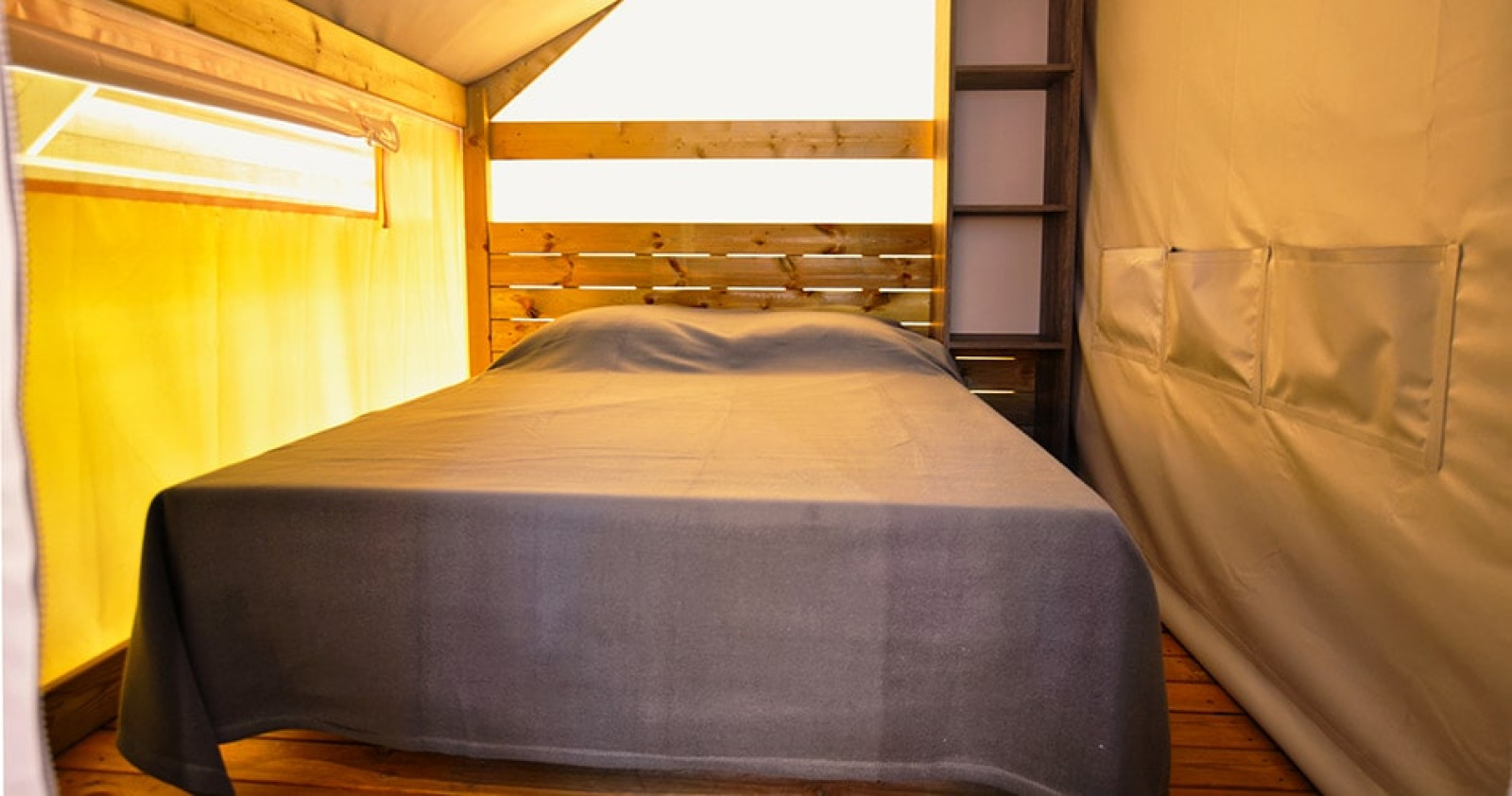 Interieur van Safari Tent Lodge Liberta op Camping Merendella in Frankrijk met een tweepersoonsbed.