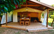 Tenda safari Lodge Riada al Camping Merendella in Francia con terrazza in legno e zona pranzo esterna.