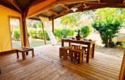 Safari-Zeltlodge mit Holzboden und offener Terrasse im Camping Merendella, Frankreich, umgeben von Natur.