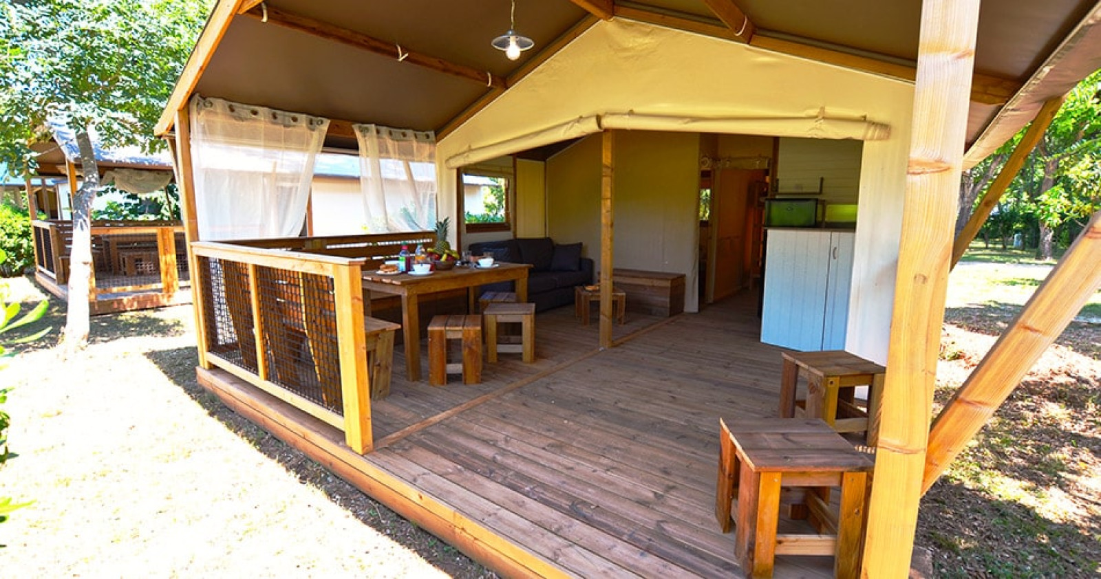 Safaritent Tent Lodge Cottu bij Camping Merendella in Frankrijk, met houten terras en buiteneethoek.