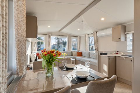 Interni luminosi e moderni della Vakantiehuis Admiral al Camping Papillon in Belgio con zona pranzo e soggiorno.