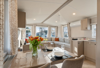 Interni luminosi e moderni della Vakantiehuis Admiral al Camping Papillon in Belgio con zona pranzo e soggiorno.