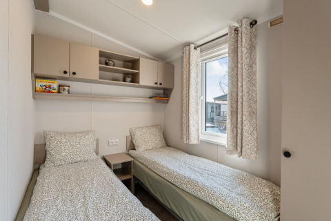 Camera moderna presso Vakantiehuis Admiral, Camping Papillon in Belgio, con due letti singoli e finestra luminosa.