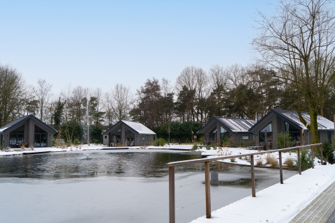 Vista invernale su Ecovilla Waterzicht Comfort, chalet sullo stagno al parco Latour, Paesi Bassi.