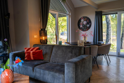 Modern living room at Ecovilla Waterzicht Comfort, Holiday park Latour, Netherlands with cozy decor and view.