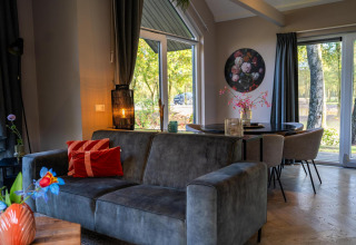 Sala moderna en Ecovilla Waterzicht Comfort, Holiday park Latour, Países Bajos, con vistas y decoración acogedora.