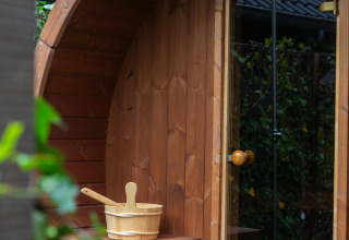 Sauna esterna in legno con secchio e mestolo presso Ecovilla Waterzicht Comfort Sauna & Buitendouche nei Paesi Bassi.