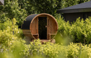 Sauna de barril en jardín verde de Ecovilla Waterzicht Comfort Sauna & Buitendouche, Holiday park Latour, Países Bajos.
