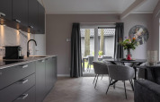 Cucina moderna e zona pranzo nell’Ecovilla Boszicht Comfort al Holiday park Latour, Paesi Bassi, vista sul giardino.