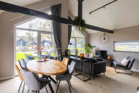 Soggiorno e sala da pranzo moderni con ampie finestre in Ecovilla Boszicht Comfort, Holiday park Latour, Olanda.