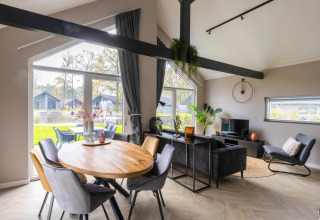 Modern living and dining space with large windows at Ecovilla Boszicht Comfort, Holiday park Latour, Netherlands.