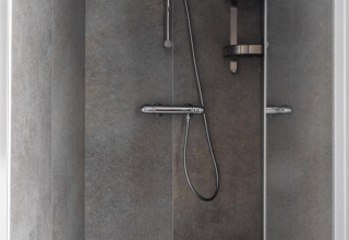 Modern shower with grey tiled walls, chrome shower head, and shelf at Villa Bosrand Comfort, Latour, NL.