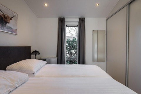 Bedroom at Villa Bosrand Comfort, Holiday park Latour, Netherlands, featuring twin beds and a bright window.