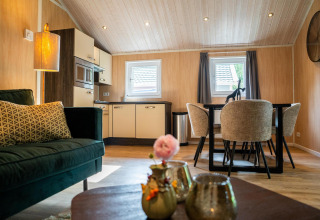 Interior de una elegante lodge con cocina y comedor en Holiday park Latour en los Países Bajos.