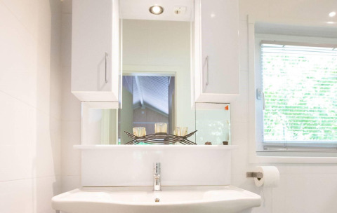 Lavabo moderno con specchio e finestra nella Lodge Deluxe Plus al Holiday park Latour, Paesi Bassi.