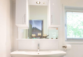 Lavabo moderno con specchio e finestra nella Lodge Deluxe Plus al Holiday park Latour, Paesi Bassi.
