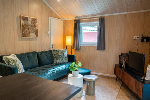 Accogliente soggiorno nella Lodge Deluxe al Holiday park Latour, Paesi Bassi, con divano verde e arredo moderno.