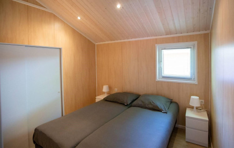 Camera da letto della Lodge Deluxe all'Holiday park Latour nei Paesi Bassi con letto doppio e legno chiaro.