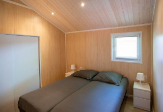 Camera da letto della Lodge Deluxe all'Holiday park Latour nei Paesi Bassi con letto doppio e legno chiaro.