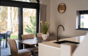 Dining table and kitchen area at Ecovilla Boszicht Luxe, Holiday park Latour, the Netherlands.