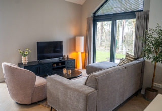 Modern living room in Ecovilla Boszicht Luxe at Holiday park Latour, Netherlands, with nature views.