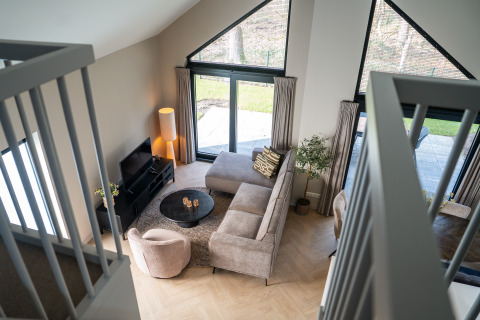 Soggiorno moderno della Ecovilla Boszicht Luxe al Holiday park Latour, Paesi Bassi, visto dall’alto.