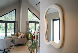 Soggiorno moderno di Ecovilla Waterzicht Luxe presso Holiday park Latour, Paesi Bassi, finestre grandi.