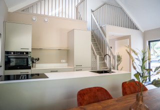 Modern kitchen and dining area in Ecovilla Waterzicht Luxe at Holiday park Latour, Netherlands.