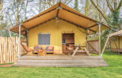 Safari-Zelt mit Holzterrasse, Sitzgelegenheiten und Picknicktisch im Wald, ideal zum Glamping.