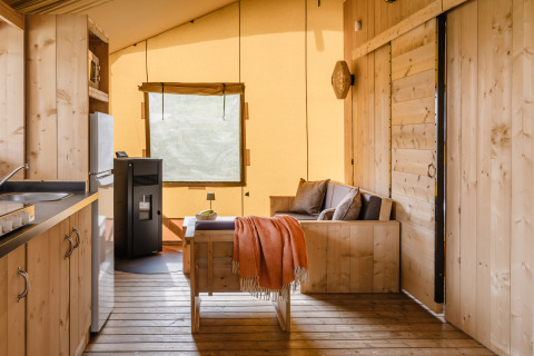 Indretning af en luksus safari-telt med træmøbler og køkken i De Heide Tent på Gooise Heide, Holland.