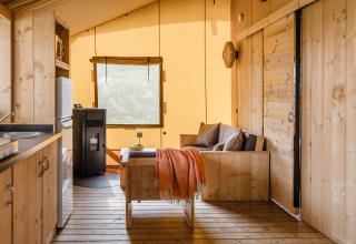 Indretning af en luksus safari-telt med træmøbler og køkken i De Heide Tent på Gooise Heide, Holland.