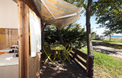 Udsigt fra træterrassen i Chalet Marina på Camping Merendella, Frankrig, med skov og havudsigt.