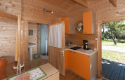 Indvendig udsigt til Chalet Marina på Camping Merendella med køkken, badeværelse og træindretning.