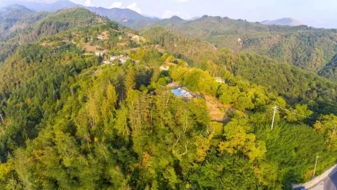 Luchtfoto van Safaritent onderste terras op Camping Pian d'Amora in Italië, te midden van groene heuvels.
