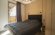 Camera da letto nella Lodge Prestige su palafitte con vista mare al Camping Merendella in Francia, stile moderno.