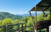 Uitzicht vanaf Safaritent premium plek op Camping Pian d'Amora in Italië, met groene bergen op de achtergrond.