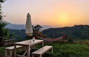 Zonsondergang met hangmat, picknicktafel en parasol bij Safaritent premium plek, Camping Pian d'Amora, Italië.