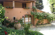 Encantadora villa en Agricampeggio La Prugnola en la Toscana, Italia, rodeada de flores y vegetación exuberante.