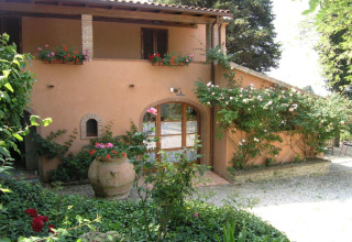Sfeervolle vakantiewoning bij Agricampeggio La Prugnola in Toscane, Italië, omringd door bloemen en planten.