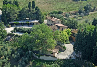 Luchtbeeld van een villa te midden van bomen en olijfbomen nabij Montescudaio, Toscane, Italië.