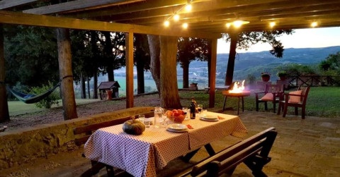 Buiten eetruimte bij Agricampeggio La Prugnola in Toscane, Italië met gezellige verlichting en barbecue.